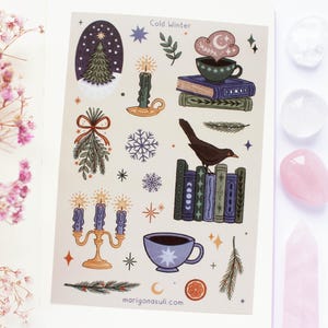以下が含まれることがあります： 「Cold Winter」をテーマにしたステッカーシート。クリスマスツリー、ろうそく、雪の結晶、本の上にいる鳥、お茶のカップのイラストが特徴です。カラーパレットは青、緑、オレンジなど。上部には「Cold Winter」の文字があります。