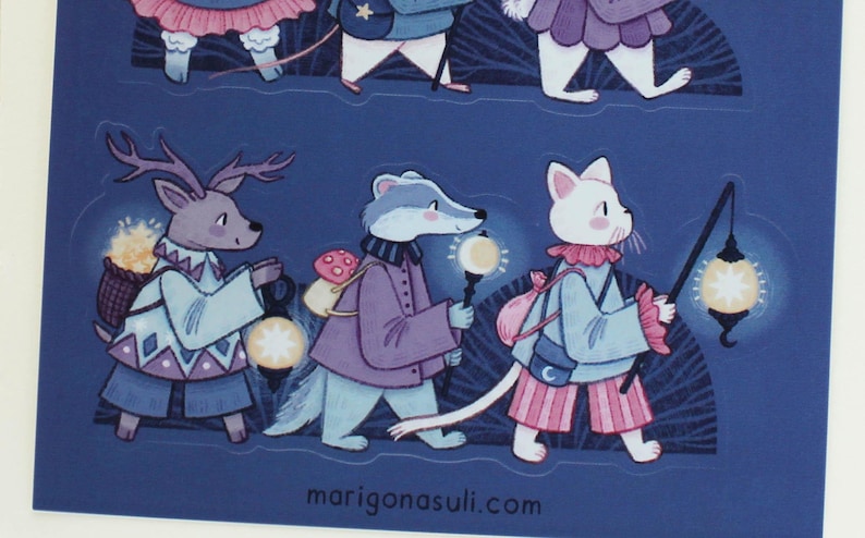 May include: A set of four illustrated stickers featuring a deer, a badger, a cat, and a rabbit. Each animal is carrying a lantern and walking on a blue background with a white star pattern. The text "marigonastuli.com" is at the bottom of the image.
