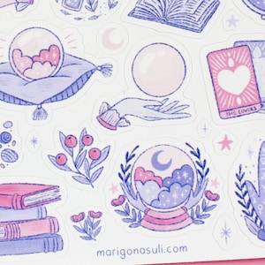 May include: A sheet of stickers featuring mystical and celestial illustrations in shades of pink, purple, and blue. Designs include a crystal ball, tarot cards, a hand with symbols, books, and floral elements. The website address marigonasuli.com is visible.