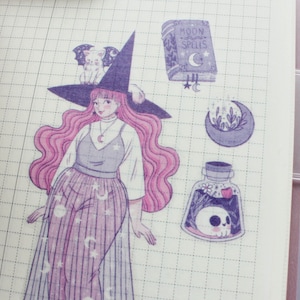 Puede incluir: Una hoja de pegatinas con una ilustraci&oacute;n morada y rosa de una bruja con un sombrero negro y un gato blanco en el sombrero. La bruja lleva un vestido morado y rosa con estrellas y lunas. La hoja de pegatinas tambi&eacute;n incluye un libro con el texto "Moon Spells", una luna creciente con flores y una botella de poci&oacute;n con una calavera dentro.
