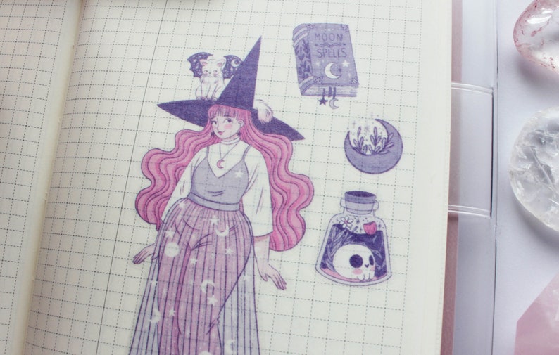 Puede incluir: Una hoja de pegatinas con una ilustraci&oacute;n morada y rosa de una bruja con un sombrero negro y un gato blanco en el sombrero. La bruja lleva un vestido morado y rosa con estrellas y lunas. La hoja de pegatinas tambi&eacute;n incluye un libro con el texto "Moon Spells", una luna creciente con flores y una botella de poci&oacute;n con una calavera dentro.