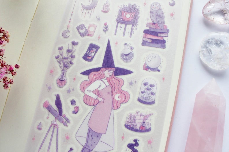 May include: A set of purple and pink witch-themed stickers featuring a witch with a pink dress and a black hat, a telescope, a crystal ball, a potted plant, and a stack of books.