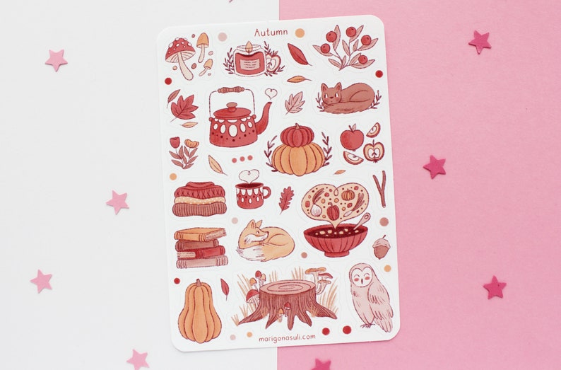 May include: A sheet of autumn-themed stickers featuring illustrations of a teapot, a pumpkin, a cat, a fox, a bowl of soup, a mushroom, a stack of books, a tree stump, an owl, and a gourd. The stickers are in shades of red, orange, and brown.