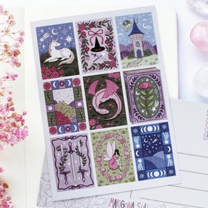 May include: A sheet of nine illustrated cards with fantasy themes, including a unicorn, witch's hat, dragon, and fairy. The cards are in a grid pattern, with a postcard and crystals in the background.