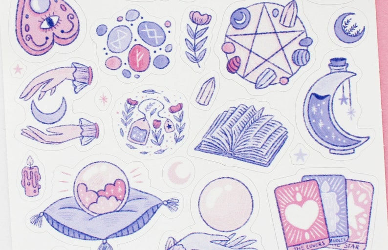 May include: A collection of whimsical stickers featuring celestial and mystical designs. Includes a crystal ball, tarot cards, a pentagram, a crescent moon bottle, hands, and other magical elements in shades of pink and purple.