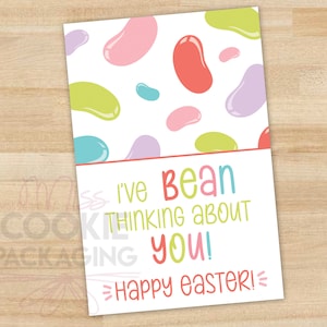 May include: A white card with a colorful jelly bean pattern at the top. The card reads "I've bean thinking about you! Happy Easter!" in playful, colorful lettering. The card is designed for Easter.
