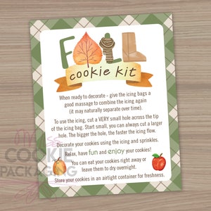 May include: A green and white plaid background with a white card featuring a fall-themed cookie kit. The card has a red banner with the text "Fall cookie kit" in brown letters. The card also includes instructions for decorating cookies and a picture of a boot, a scarf, and an apple.