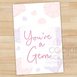 May include: A white card with a pink background and pink and purple diamond shapes. The text "You're a Gem" is written in pink cursive.
