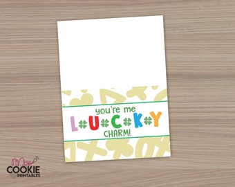 Puede incluir: Una tarjeta blanca con un borde verde y un fondo amarillo con tréboles verdes. El texto "You're me lucky charm!" está escrito en letras de colores.