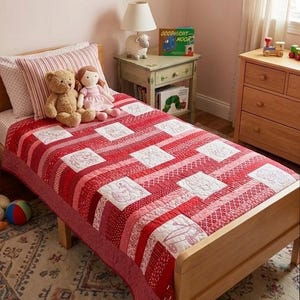 May include: A red and white patchwork quilt on a wooden bed. The quilt features embroidered squares with various designs. A teddy bear and a doll sit on the bed. A nightstand with a lamp and books is next to the bed.