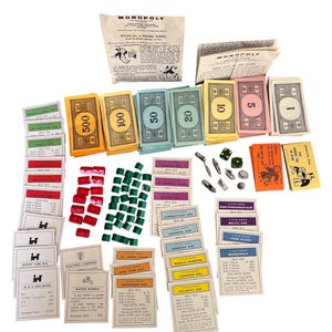 Pezzi del gioco Monopoly d'epoca, hotel e case, denaro, carte mutuo, carte cassa comune, carte probabilità, gettoni, diario di gioco, tecniche miste