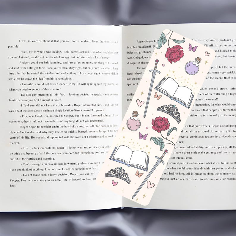May include: A bookmark with a white background and a variety of illustrations, including a sword, a crown, a book, a potion bottle, a rose, and butterflies. The bookmark has a gold glitter effect.