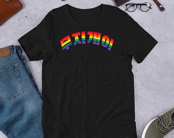 Peut inclure: T-shirt noir avec texte coréen arc-en-ciel. Le texte est en dégradé arc-en-ciel. Le t-shirt est à manches courtes et a un col rond. Le t-shirt est posé sur une surface gris clair avec d'autres articles.