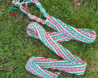 Può includere: Una treccia intrecciata in rosso, bianco e verde. La treccia è composta da più fili di filo e è legata alle estremità.