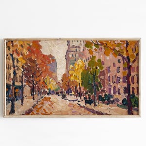 May include: An oil painting in a light wood frame depicting a city street scene during autumn. The artwork features thick, textured brushstrokes in shades of orange, yellow, green, and brown, capturing trees lining a road with buildings in the background.