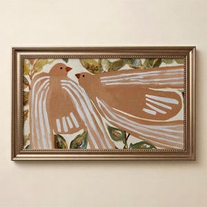 Puede incluir: Una pieza de arte mural rectangular enmarcada que presenta una pintura de dos aves estilizadas en tonos bronce y blanco. Las aves están situadas sobre un fondo de follaje verde y marrón. El marco es de bronce metálico con un borde de cuentas.