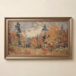 May include: A rectangular landscape painting in a metallic gold frame featuring an autumn forest scene with orange, yellow, and red foliage, tall evergreen trees, and a cloudy sky above a grassy field with visible brushstrokes throughout the artwork.