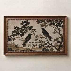 May include: A rectangular wall art piece featuring a dark brown wooden frame with a beaded inner edge. The print depicts two black crows perched on tree branches against a muted, light-coloured background with a landscape of trees and foliage.