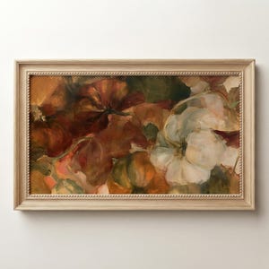 May include: A rectangular framed wall art piece featuring an oil painting of various pumpkins in shades of deep orange, muted green, and creamy white. The frame is made of light-toned wood with a beaded inner edge detail surrounding the artwork.