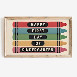May include: A framed print featuring five colorful crayon illustrations. Each crayon is a different color: red, teal, green, yellow-orange, and pink. The text "HAPPY FIRST DAY OF KINDERGARTEN" is displayed on the crayons in white letters.