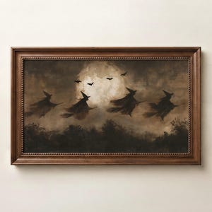 Peut inclure: Une œuvre d'art murale encadrée rectangulaire représentant une peinture sombre et atmosphérique de quatre silhouettes de sorcières volant sur des balais devant une grande pleine lune lumineuse, avec des chauves-souris et une forêt sombre.