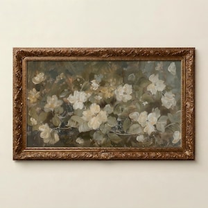 Op de afbeelding: Een olieverfschilderij van witte bloemen met groene bladeren, tegen een achtergrond van gedempte groen- en blauwtinten. Het kunstwerk is ingelijst in een gedetailleerde, sierlijke, bruine houten lijst, wat een klassieke touch geeft.