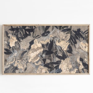 May include: Abstract art print in a rectangular wooden frame. The artwork features a mix of black, beige, and gray tones, with leaf-like shapes and textured patterns. The overall aesthetic is modern and natural.