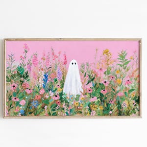 May include: A framed art print featuring a white ghost figure standing in a field of colorful wildflowers. The background is a solid pink color. The artwork is in a wooden frame.