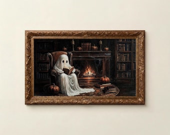 May include: A framed wall art print depicting a white ghost sitting in a brown armchair reading a book. The scene includes a fireplace with a fire, bookshelves, and orange pumpkins. The frame is ornate, metallic gold with detailed carvings.