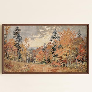 May include: A rectangular landscape painting in a dark brown wooden frame depicting an autumn forest scene with orange, yellow, and red foliage on trees, dark green pine trees, and a cloudy, overcast sky above a grassy, textured foreground.