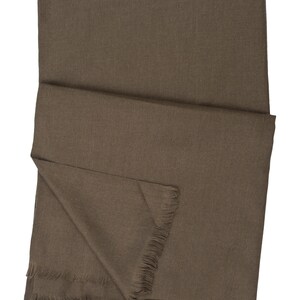 May include: A brown woven scarf with fringed edges.