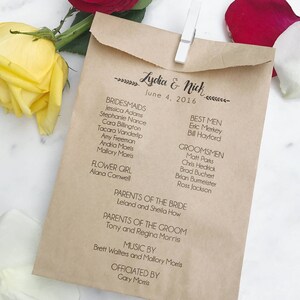 Puede incluir: Un programa de boda de papel kraft, sujeto con una pinza blanca, con los nombres de la comitiva nupcial y la familia. El programa está adornado con motivos florales y los nombres "Lydia & Nick" y la fecha "4 de junio de 2016". Rosas rojas y amarillas en el fondo.