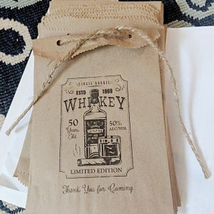 Puede incluir: Bolsas de papel marr&oacute;n con un dise&ntilde;o de etiqueta de whisky vintage. La etiqueta presenta una botella de whisky, un vaso y un cigarro. El texto de la etiqueta dice "Single Barred, Est. 1969, Whiskey, 50 Years Old, 50% Alc/Vol, Limited Edition, Thank You for Coming."