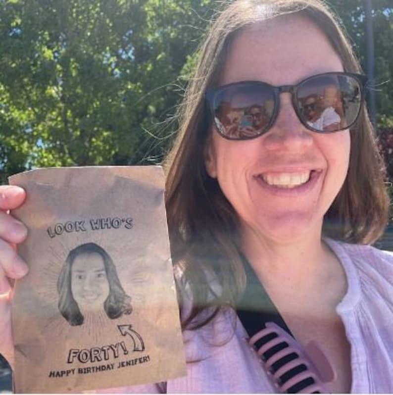 Puede incluir: Una tarjeta marr&oacute;n con el texto "Look Who's Forty! Happy Birthday Jenifer!" y una foto de una mujer con cabello casta&ntilde;o.