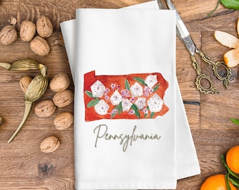 Peut inclure: Une serviette de cuisine blanche avec un contour rouge de l'état de Pennsylvanie orné de fleurs blanches et de feuilles vertes. Le texte "Pennsylvanie" est écrit en cursive sous le contour de l'état.