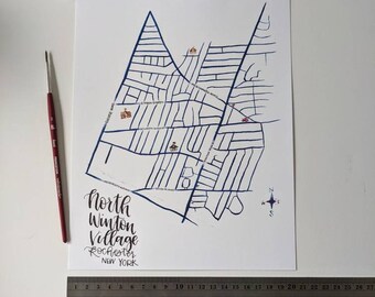 Peut inclure: Une carte dessinée à la main du village de North Winton à Rochester, New York. La carte est dessinée à l'encre bleue sur du papier blanc et comprend des noms de rues et une boussole.