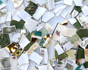 Peut inclure: Un ensemble de morceaux de céramique cassés de formes et tailles variées. Les fragments présentent un mélange de couleurs, dont le blanc, le vert, l'or et des motifs floraux. Certaines pièces ont une finition brillante, d'autres sont mates.