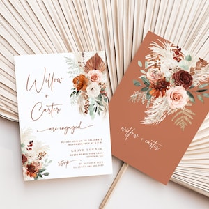 Könnte beinhalten: Zwei Verlobungs-Einladungen im Boho-Stil. Die Einladungen zeigen ein Aquarell-Blumenmuster mit Pampasgras und einem Terrakotta-Hintergrund. Der Text auf den Einladungen lautet "Willow + Carter sind verlobt".