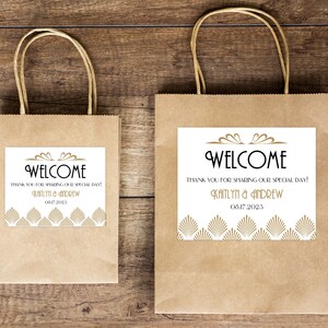 May include: Two brown paper gift bags with white labels. The labels have gold geometric designs and the text "WELCOME" with the message "Thank you for sharing our special day!" and the names "Kaitlyn & Andrew" and the date "08.17.2023".