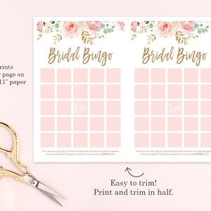 May include: Two pink and white Bridal Bingo game sheets with floral accents and gold text. The text reads "Bridal Bingo" and "free" in the center. The sheets are designed to print two per 8.5" x 11" paper. Scissors are in the lower left corner.