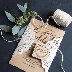 K&ouml;nnte beinhalten: Eine rustikale Hochzeitseinladung mit braunem Papierhintergrund und wei&szlig;er Spitzen&uuml;berlagerung. Die Einladung enth&auml;lt den Text "Sie sind eingeladen, die Hochzeit zu feiern" und das Datum "10.23.18".
