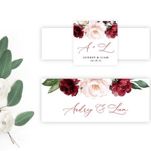 Puede incluir: Tarjetas de lugar de boda con un diseño floral burdeos y rubor. Las tarjetas llevan los nombres "Audrey & Liam" y la fecha "09.18.23".