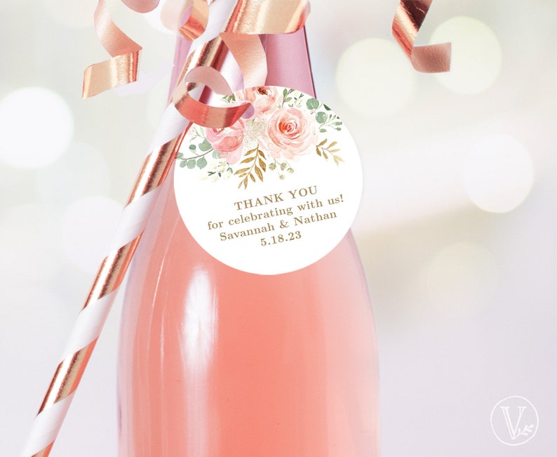 May include: A round white favor tag with pink and green floral illustrations and gold lettering. The tag says "Thank you for celebrating with us! Savannah & Nathan 5.18.23".