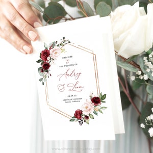 May include: Wedding invitation featuring a gold geometric frame and floral design. The text reads "Welcome to the wedding of Audrey & Liam 09.18.23 Grenville Vineyards Sonoma, California"