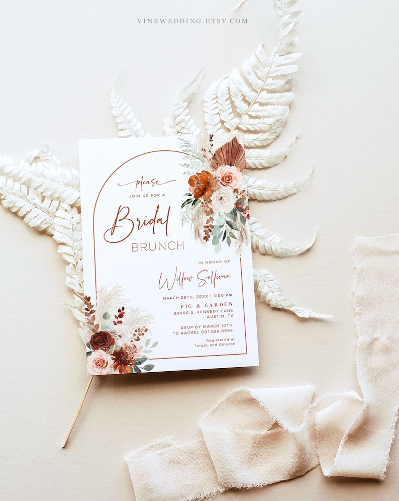 May include: A white card with a brown archway and floral design. The text reads "Please join us for a Bridal Brunch in honor of Willow Sullivan, March 28th, 20XX at 3:00 PM, Fig & Garden, 89000 S. Kennedy Lane, Austin, TX. RSVP by March 10th to Rachel 001.888.9999. Registered at Target and Amazon."