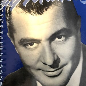 Könnte beinhalten: Ein Schwarzweißfoto von Tony Martin, einem Sänger und Schauspieler, auf blauem Hintergrund. Das Foto stammt von einem Vintage-Albumcover.