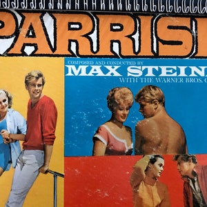 May include: A vintage record album cover featuring a colorful image of four people. The album is titled "Parrish" and is composed and conducted by Max Steiner with the Warner Bros. Orchestra.