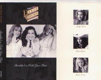May include: A cassette tape cover featuring a photo of three women, the Dixie Chicks, with the title "Shouldn't a Told You That" and the band's name and logo.