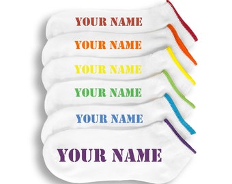 May include: Six pairs of white ankle socks with a rainbow colored trim. Each sock has the text "YOUR NAME" printed in a bold, dark font.
