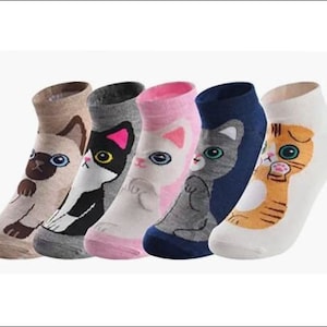 May include: Five pairs of ankle socks with cat designs. Each sock features a different cat illustration in various colors, including brown, black, pink, gray, and orange. The socks are made of a soft material and are ideal for casual wear.